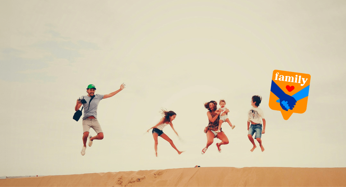 Famiglia che salta su una duna