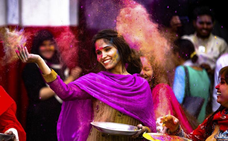 ragazza che lancia i colori Holi Festival